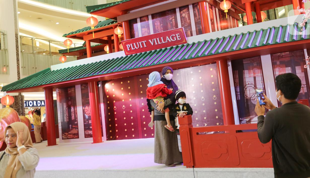 Pengunjung saat foto berlatar belakang rumah Tiongkok di Pluit Village Jakarta Utara (23/02/2022). Pluit Village juga menampilkan rangkaian kegiatan seperti, barongsai tonggak, akrobatik barongsai, liong dance, dan beberapa kompetisi mandarin sing baby kids barongsai. (Liputan6.com/Fery Pradolo)
