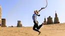 Seorang wisatawan bermain pasir di kawasan wisata Gurun Kum Tag di Wilayah Shanshan, Kota Turpan, Daerah Otonom Uighur Xinjiang, China barat laut (22/9/2020). Gurun tersebut saat ini mencatat peningkatan arus wisatawan. (Xinhua/Wang Fei)