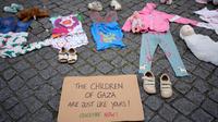 Sebuah instalasi pakaian dan mainan anak-anak tersebar di sepanjang jalan Carmo di pusat kota Lisbon, Portugal, Jumat, 30 Mei 2025. (AP Photo/Armando Franca)