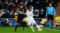 Pemain Inter Milan Alessandro Bastoni (kiri) berebut bola dengan pemain Real Madrid Luka Modric pada pertandingan sepak bola Grup D Liga Champions di Stadion Santiago Bernabeu, Madrid, Spanyol, 7 Desember 2021. Real Madrid menang 2-0. (PIERRE-PHILIPPE MARCOU/AFP)