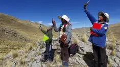 Cabrera bersaudara mencari sinyal di atas bukit untuk menghadiri kelas virtual di komunitas dataran tinggi Conaviri yang terpencil di Andes Peru, 24 Juli 2020. Sejak sekolah ditutup akibat COVID-19, mereka bergantung pada ponsel untuk mengakses platform "Belajar di Rumah".  (Carlos MAMANI/AFP)