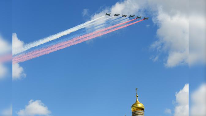 Pesawat tempur Su-25 melepaskan asap dengan warna bendera Rusia saat terbang di atas Ivan the Great Bell Tower di Kremlin saat latihan untuk parade militer Hari Kemenangan di Moskow, Kamis (4/5). (AFP PHOTO / Natalia KOLESNIKOVA)