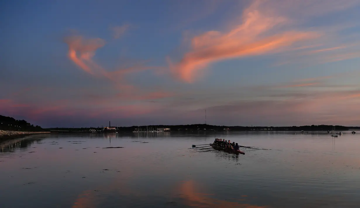 Sejumlah pedayung berlatih saat matahari terbit di teluk Casco Bay, Portland, Maine (21/8/2019). Pemukiman pertama di Casco Bay adalah milik Kapten Christopher Levett, seorang penjelajah Inggris, yang membangun sebuah rumah di House Island pada tahun 1623–24. (AP Photo/Robert F. Bukaty)