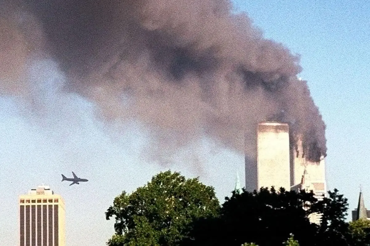 Sebuah pesawat mendekati World Trade Center (WTC) New York sebelum menabrak menara di sebelah kiri, seperti yang terlihat dari pusat kota Brooklyn, Selasa, 11 September 2001.(Foto AP / William Kratzke)