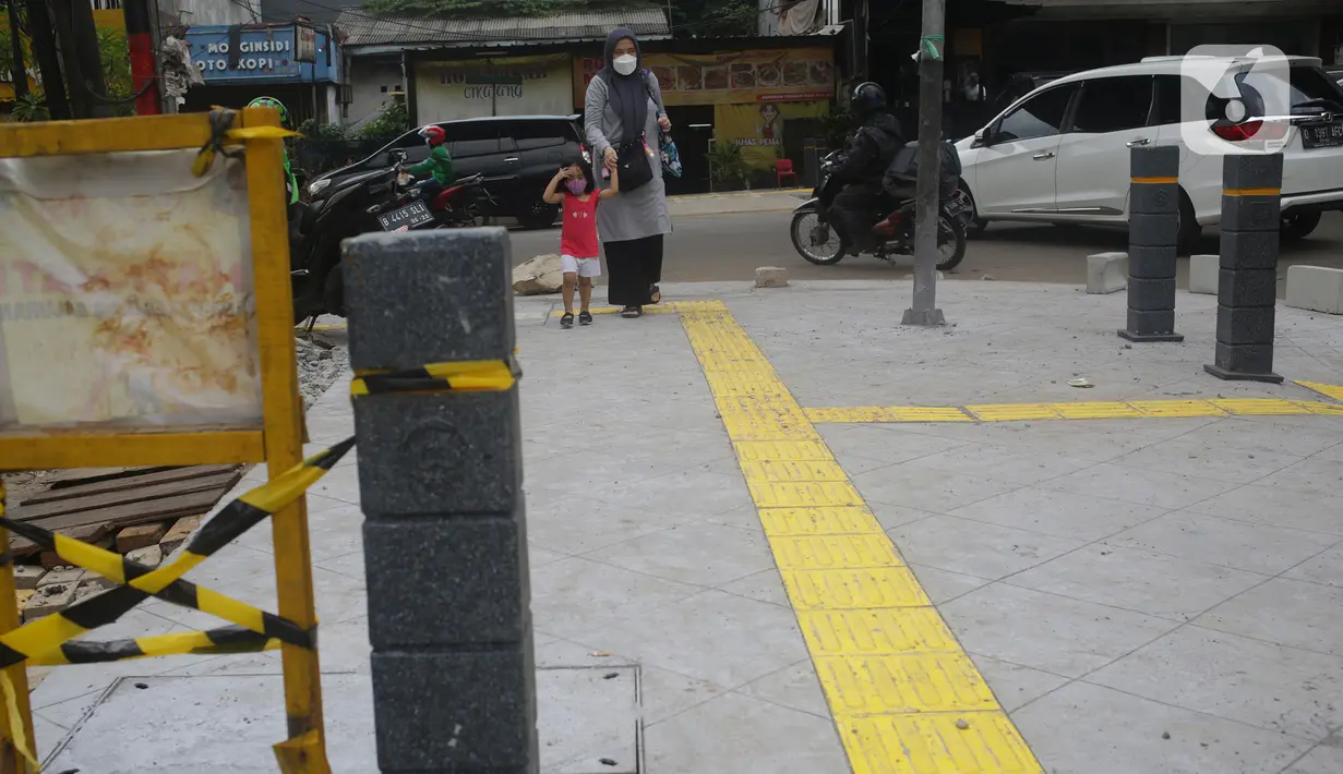 Pejalan kaki melintas di atas trotoar di kawasan Senopati, Kebayoran Baru, Jakarta, Rabu (15/9/2021). Pemprov DKI Jakarta melalui Dinas Bina Marga merevitalisasi 10 ruas jalan di lima wilayah kota adminsitrasi Jakarta sampai akhir tahun 2021. (Liputan6.com/Herman Zakharia)