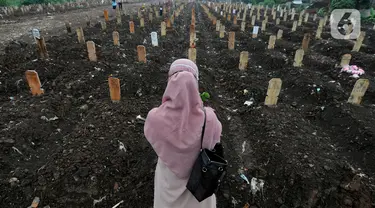 Keluarga berdoa depan pusara makam korban Covid-19 di TPU Srengseng Sawah 2, Jakarta Selatan, Jumat (19/3/2021). Seminggu terakhir intensitas pemakaman korban Covid-19 menurun drastis sebesar rata-rata 20 jenazah/minggu dibandingkan sebelumnya rata-rata 35 jenazah/minggu. (merdeka.com/Arie Basuki)