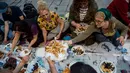 Orang-orang berbagi makanan dengan yang lain saat berbuka puasa bersama di dekat Taksim Square, Istanbul, Turki, Rabu (16/5). (Yasin AKGUL/AFP)