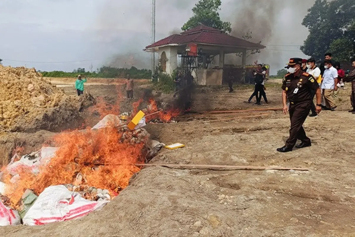 Kepala Kejari Pekanbaru melemparkan sepatu dalam pemusnahan barang bukti tindak pidana yang sudah berkekuatan hukum tetap.