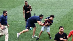 Seorang  fans mengejar penyerang Barcelona, Lionel Messi saat sesi latihan di Red Bull Arena di Harrison, New Jersey, (21/7). Barcelona akan berhadapan dengan Juventus pada ICC 2017. (AFP Photo/Jewel Samad) 