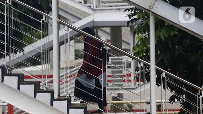 Warga menaikii tangga JPO di Jalan HR Rasuna Said, Jakarta, Kamis (7/1/2021). Untuk menyeragamkan kebijakan pengendalian COVID-19, Gubernur DKI Jakarta akan segera menerbitkan Pergub untuk Pemberlakuan Pembatasan Kegiatan Masyarakat (PPKM) pada 11-25 Januari 2021. (Liputan6.com/Helmi Fithriansyah)