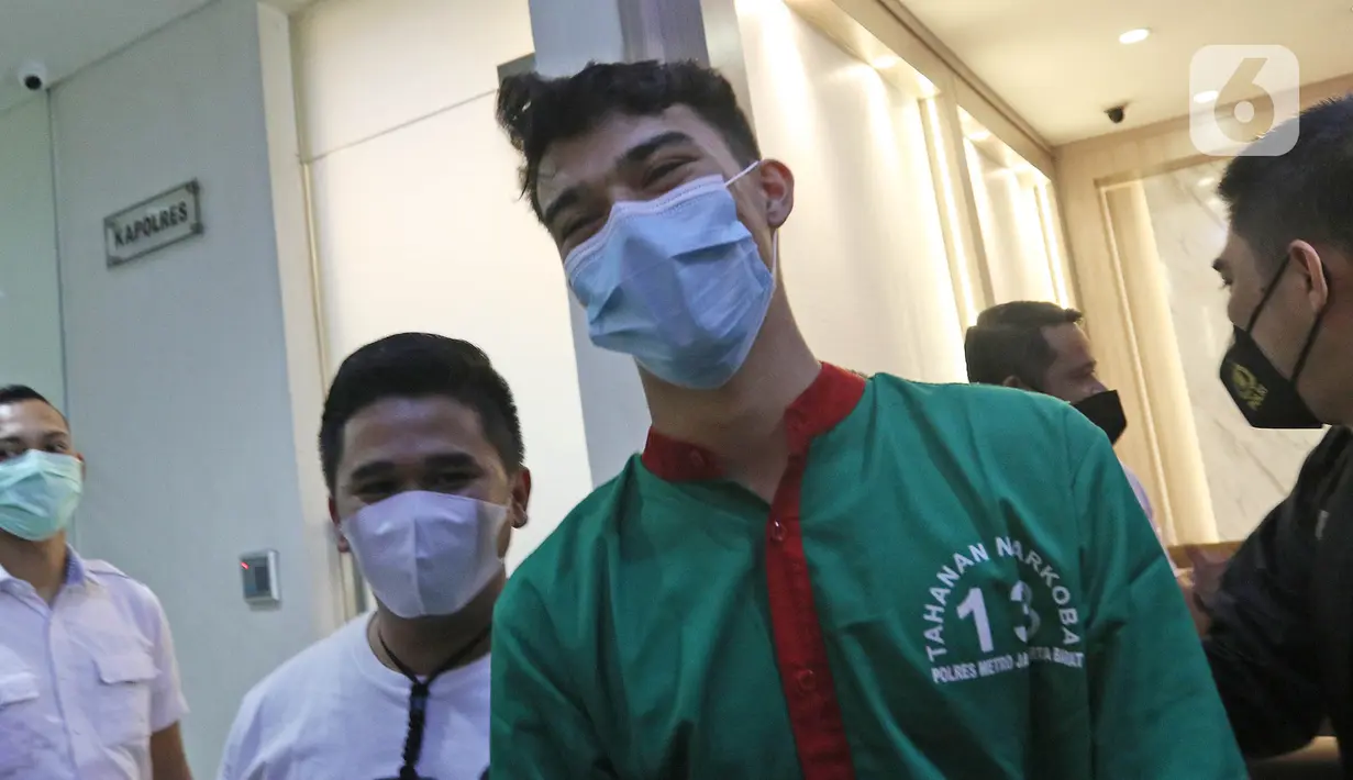 Petugas membawa pesinetron Jeff Smith untuk dihadirkan dalam rilis kasus penyalahgunaan narkoba di Polres Metro Jakarta Barat, Senin (19/4/2021). Diketahui, berdasarkan hasil tes urine, Jeff Smith dinyatakan positif mengonsumsi narkoba jenis ganja. (Liputan6.com/Herman Zakahria)