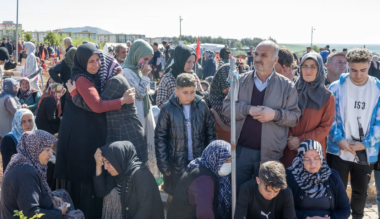 Orang-orang meratapi para korban yang dilanda gempa pada hari pertama Idul Fitri di pemakaman, di Adiyaman, Turki pada 21 April 2023. (AFP/BULENT KILIC)