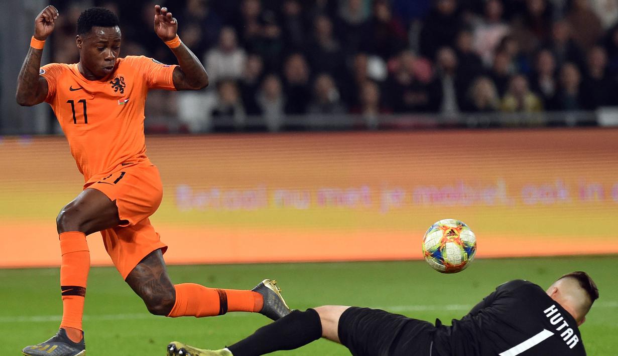 Striker Belanda, Quincy Promes, berusaha mengecoh kiper Belarusia, Aliaksandr Hutar, pada laga Kualifikasi Piala Eropa 2020 di Minsk, Minggu (13/10). Belarusia kalah 1-2 dari Belanda. (AFP/Sergei Gapon)