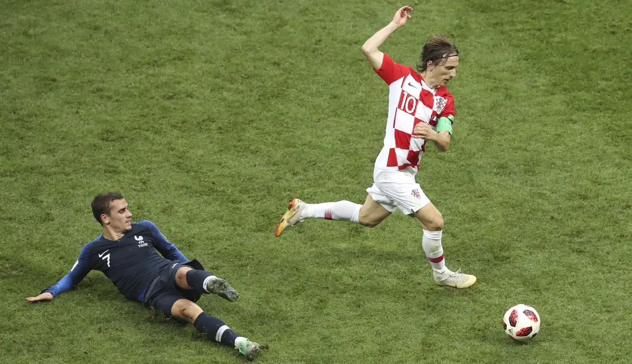 Penyerang Prancis, Antoine Griezmann, berebut bola dengan kapten Kroasia, Luka Modrid, pada laga final Piala Dunia di Stadion Luzhniki, Moskow, Minggu (15/7/2018). Prancis menang 4-2 atas Kroasia. (AP/Thanassis Stavrakis)