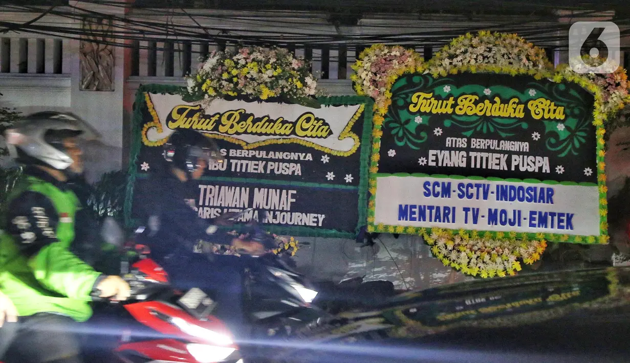 Deretan karangan bunga ucapan turut berduka cita terpampang di sepanjang jalan depan rumah duka penyanyi legendaris, Titiek Puspa di kawasan Pancoran, Jakarta Selatan, pada Kamis (10/4/2025) malam. (Liputan6.com/Angga Yuniar)