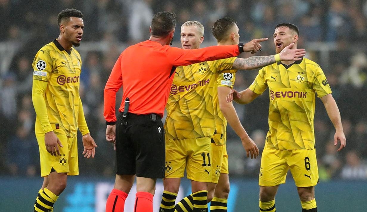 Wasit Artur Dias berdiskusi dengan para pemain Dortmund saat pertandingan sepak bola Grup F Liga Champions antara Newcastle dan Dortmund di St. James' Park, Newcastle, Inggris, Rabu (25/10/2023). (AP Photo/Scott Heppell)
