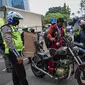 Petugas kepolisian lalu lintas memberhentikan pengendara motor saat Operasi Zebra Jaya 2020 di kawasan Cawang, Jakarta, Senin (26/10/2020). Operasi Zebra Jaya dilaksanakan pada 26 Oktober-8 November 2020 untuk menekan jumlah pelanggaran lalu lintas. (Liputan6.com/Faizal Fanani)