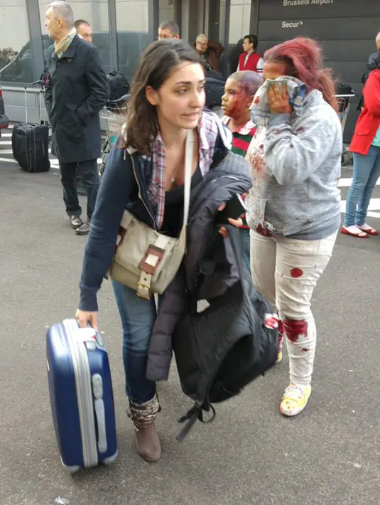 Seorang wanita tampak terburu - buru saat meninggalakn lokasi ledakan di bandara Zaventem dekat Brussels, Belgia, (22/3).Selain terjadi ledakan di Bandara, ledakan juga menghancurkan stasiun metro Maalbeek Brussels. (REUTERS/David Crunelle)