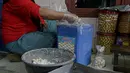 Pekerja memasukan kue kerineg ke dalam kaleng di sebuah industri rumahan di Kawasan Kwitang, Jakarta, Jumat (30/4/2021). Pandemi Covid-19 yang masih terjadi berimbas pada industri rumahan kue kering tersebut. (Liputan6.com/Faizal Fanani)