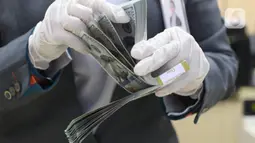 Karyawan bank menghitung uang dolar Amerika Serikat (AS) di Jakarta, Senin (2/11/2020). Nilai tukar rupiah pada perdagangan Senin (2/11) sore ditutup melemah 0,1 persen ke level Rp14.640 per dolar AS, dari perdagangan sebelumnya yaitu Rp14.690 per dolar AS. (Liputan6.com/Angga Yuniar)