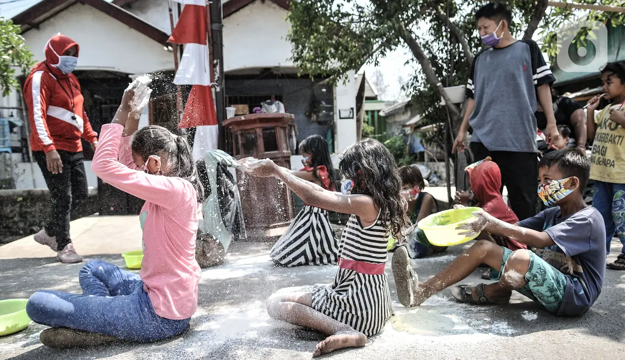 Anak-anak mengenakan masker saat mengikuti lomba memperingati HUT ke-75 RI di Kampung Nelayan, Cilincing, Jakarta, Senin (17/8/2020). Meski dilarang menggelar perlombaan akibat Covid-19, warga di Kampung Nelayan tetap mengadakan lomba 17-an walaupun hanya beberapa jenis. (merdeka.com/Iqbal Nugroho)