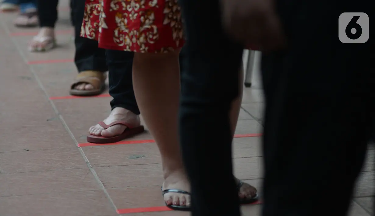 Antrean warga keturunan Tionghoa untuk sembahyang saat perayaan Tahun Baru Imlek 2572 di Vihara Dharma Bhakti, Glodok, Jakarta, Jumat (12/2/2021). Perayaan Imlek tahun ini, pengurus vihara melakukan pembatasan pengunjung dan tetap mengikuti protokol kesehatan COVID-19. (merdeka.com/Imam Buhori)