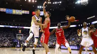 Stephen Curry #30 memberikan umpan kepada rekannya saat diadang para pebasket Houston Rockets pada laga perdana NBA 2017 di Oracle Arena, Oakland, (17/10/2017).  Rockets menang 122-121. Rockets menang 122-121. (Ezra Shaw/Getty Images/AFP)