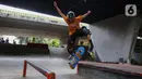 Salah satu remaja saat bermain papan seluncur atau skateboard di taman seluncur (skatepark) dan lintasan sepeda BMX di kolong jalan layang tol dalam kota, Slipi, Jakarta, Selasa (13/5/2025). (Liputan6.com/Angga Yuniar)