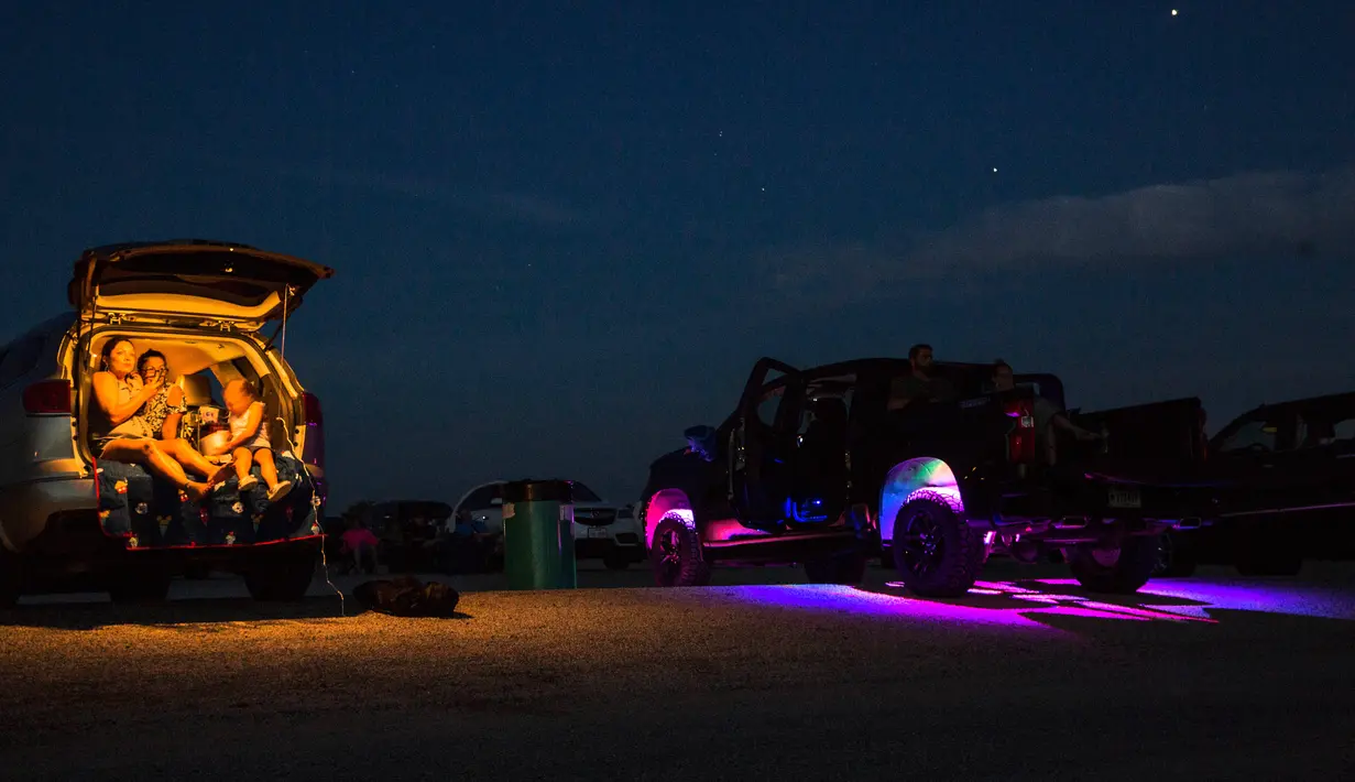 Orang-orang menonton film "Encore Drive-In Nights Presents Blake Shelton," di Stars & Stripes Drive-In Theatre, Texas pada 25 Juli 2020. Konser yang menampilkan Blake Shelton bersama Gwen Stefani ini ditayangkan di bioskop drive-in seluruh Amerika Utara. (Mikala Compton/Herald-Zeitung via AP)
