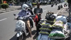 Pedagang arang melayani pembeli di kawasan Manggarai, Jakarta Selatan, Minggu (10/7/2022). Perayaan Idul Adha membawa berkah tersendiri bagi para pedagang arang musiman di kawasan Manggarai karena banya warga membeli untuk tradisi membakar sate. (merdeka.com/Iqbal S. Nugroho)