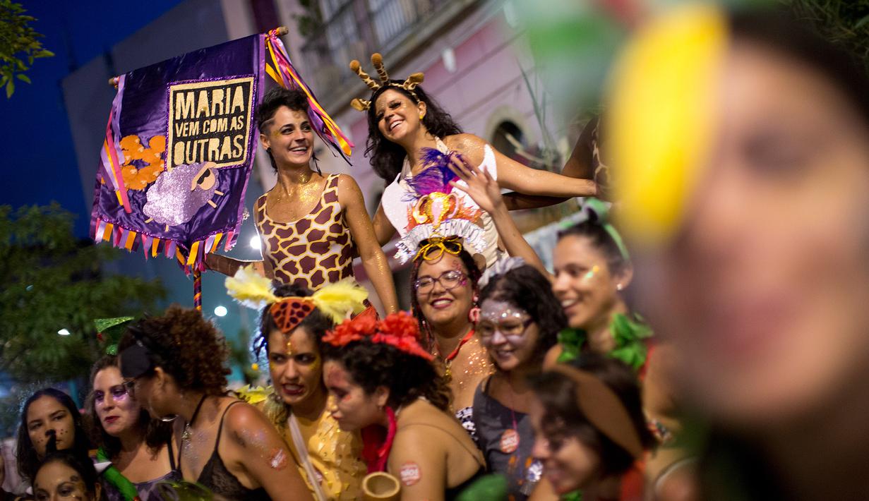 Sejumlah wanita ke jalan untuk merayakan karnaval "Maria vem com as outras" di Rio de Janeiro, Brasil (3/2). Karnaval ini digelar agar mendorong wanita di Brasil melaporkan pelecehan jika terjadi pada mereka. (AP Photo / Silvia Izquierdo)