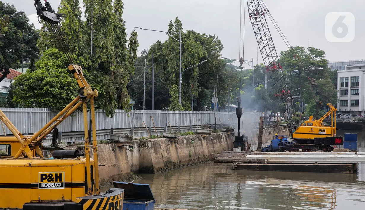 Pekerja menyelesaikan pemasangan dinding turap di kali pasar baru, Jakarta, Rabu (9/3/2022). Dinas Sumber Daya Air DKI Jakarta melakukan pemasangan turap bertujuan untuk mengantisipasi banjir serta tanah ambles di pinggir sungai. (Liputan6.com/Faizal Fanani)