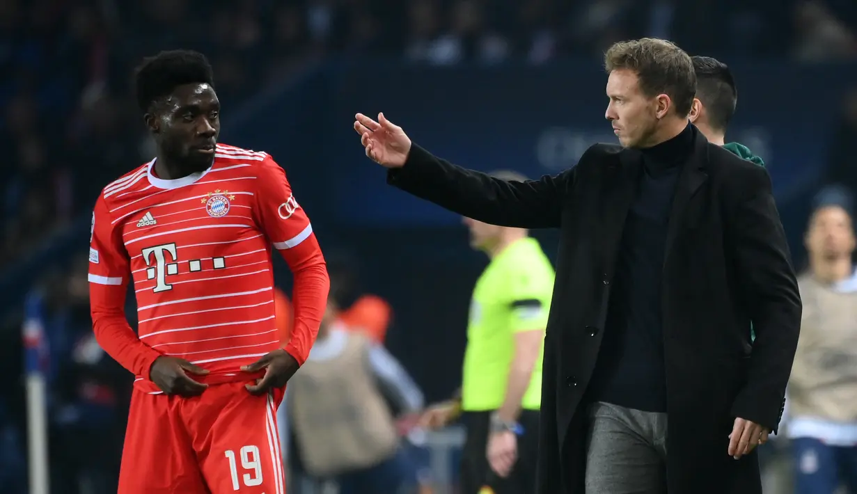 Pelatih Julian Nagelsmann (kanan) berbicara dengan gelandang Bayern Munchen  Alphonso Davies selama pertandingan Liga Champions UEFA menghadapi Paris Saint-Germain (PSG) di Parc des Princes di Paris, pada 14 Februari 2023. Kabar mendadak pemecatan Nagelsmann tersebut cukup membuat kegemparan di tengah jadwal jeda internasional musim ini. (FRANCK FIFE/AFP)