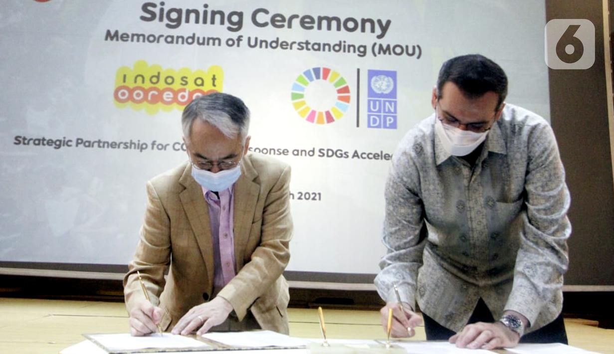 Resident Representative UNDP Indonesia, Norimasa Shimomura (kiri) dan Presdir & CEO Indosat Ooredoo, Ahmad Al-Neama (kanan) menandatangani MoU penanggulangan pandemi COVID-19 dan percepatan pencapaian Tujuan Pembangunan Berkelanjutan (SDGs) di Jakarta, Rabu (31/3/2021). (Liputan6.com/Pool/Indosat)