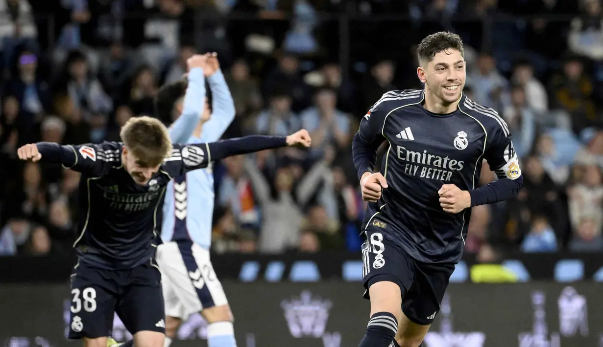 Kemenangan ini memastikan persaingan perebutan gelar juara La Liga 2025/2026 tetap sengit. Saat ini Real Madrid berada di posisi dua klasemen dengan 63 poin. Tampak dalam foto, gelandang Real Madrid asal Uruguay, Federico Valverde (kanan), merayakan golnya pada pertandingan pekan ke-27 La Liga 2025/2026 melawan Celta Vigo di Estadio Abanca-Balaidos pada Jumat 6 Maret 2026 waktu setempat atau Sabtu 7 Maret 2026 dini hari WIB. (Miguel RIOPA/AFP)