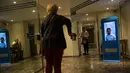 Seorang wanita memasuki sebuah gedung di Buenos Aires, Argentina, Senin (23/4). Penjaga keamanan virtual memantau setiap pengunjung yang ingin keluar masuk gedung. (AP Photo/Rodrigo Abd)