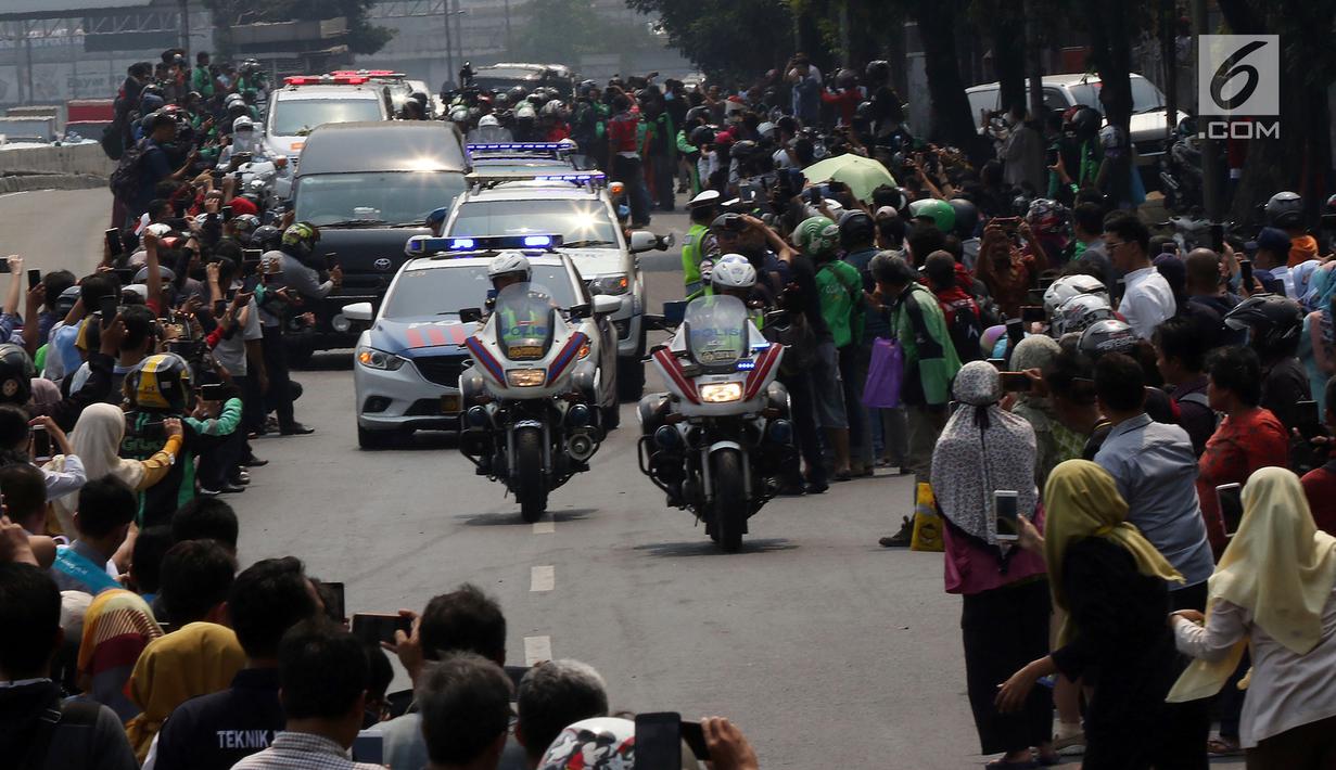 Warga antusias melihat iring-iringan mobil jenazah yang membawa almarhum Presiden ke-3 RI, BJ Habibie saat melintasi Jalan Gatot Subroto menuju TMP Kalibata, Jakarta, Kamis (12/9/2019). BJ Habibie meninggal pada Rabu (11/9/2019) setelah menjalani perawatan di RSPAD. (Liputan6.com/Johan Tallo)