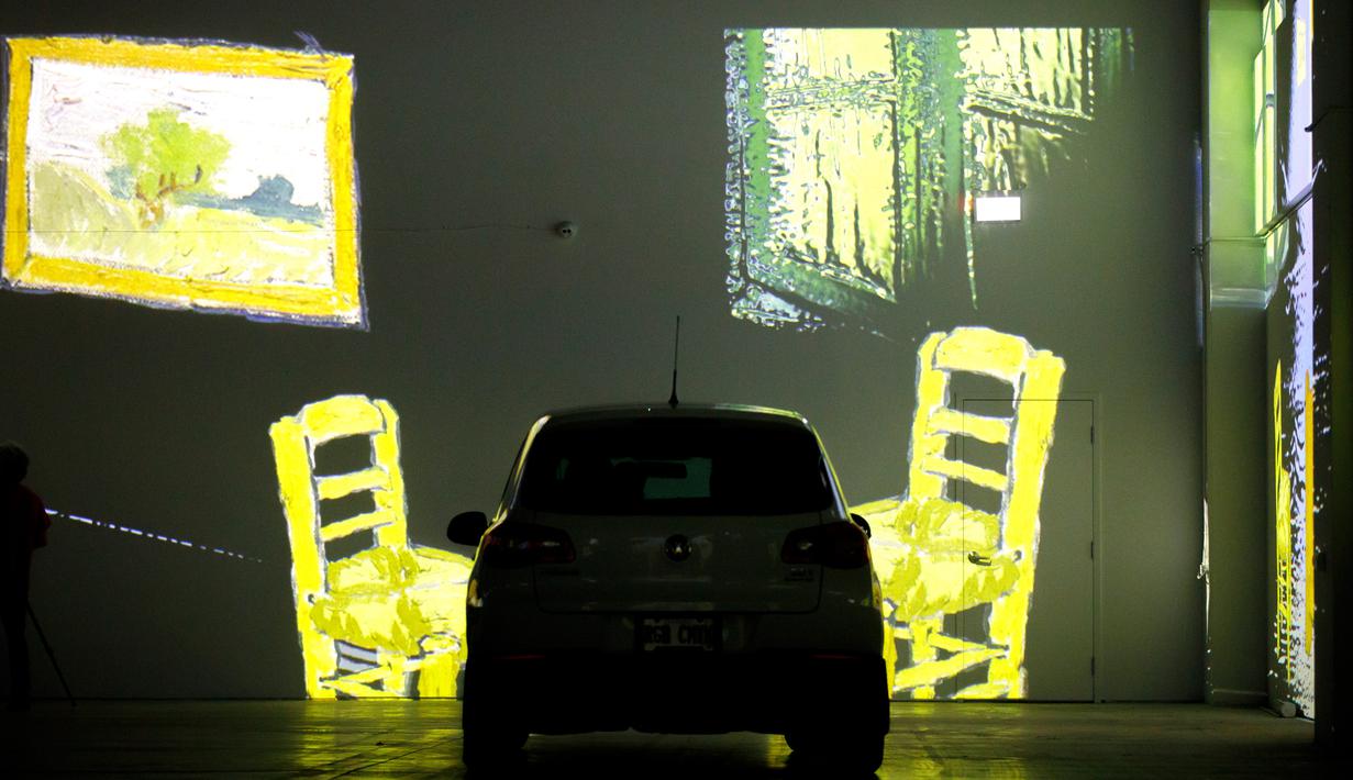 Orang-orang duduk di mobil mereka menikmati pameran seni Vincent Van Gogh di Toronto, Ontario, Kanada pada 3 Juli 2020. Pameran seni di masa pandemi Covid-19 mendatangkan ide kreatif para penyelenggara kegiatan dengan memamerkan hasil karya seni lewat konsep drive-in. (Cole BURSTON/AFP)