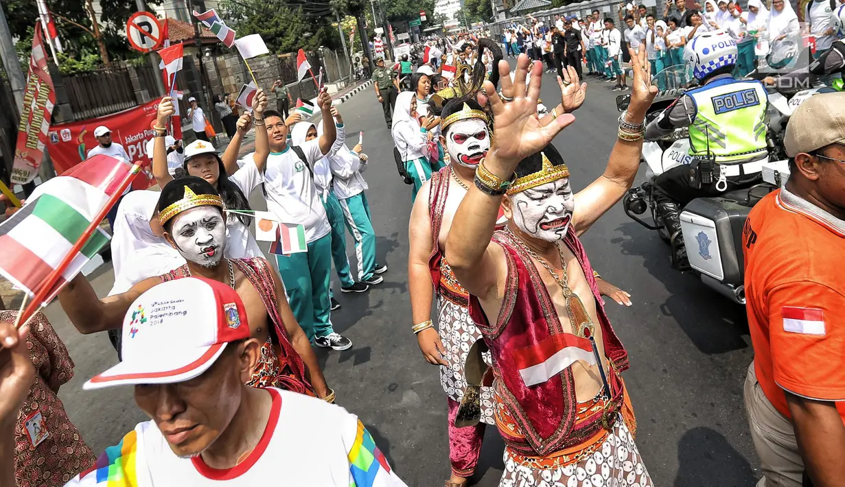 Pawai obor yang memasuki hari kedua dimulai dari Balai Kota DKI Jakarta dan berakhir di Gor Sunter di sambut meriah masyarakat jakarta dengan menggunakan wayang orang. (Liputan6.com/Faizal Fanani)