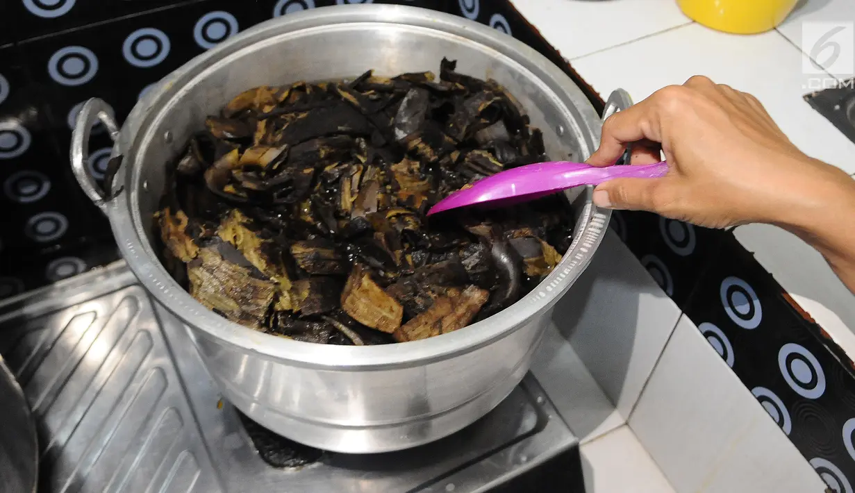 Pekerja merebus kulit pisang untuk membuat kerupuk kulit pisang di  Industri rumahan kawasan Depok, Jawa Barat, Senin (4/3/2019). Dalam sehari Industri rumahan tersebut mampu menghabiskan bahan baku 24 kilogram kulit pisang. (Liputan6.com/Herman Zakharia)