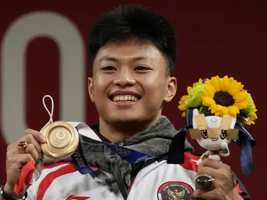 Lifter Indonesia, Rahmat Erwin Abdullah menyumbang medali ketiga bagi Indonesia dari cabang angkat Besi kelas 73 kg putra di Olimpiade Tokyo 2020, Rabu (28/7/2021). Ia meraih medali perunggu usai menempati posisi teratas di Grup B, dan ketiga secara keseluruhan. (Foto: AP/Luca Bruno)