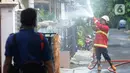 Petugas Damkar menyemprotkan cairan disinfektan pada pemukiman RW 21 Keluarahan Benda Baru, Tangerang Selatan, Banten, Kamis (1/7/2021). Penyemprotan dilakukan pada kawasan zona merah dimana di wialayah ini 46 warga terpapar Covid-19. (merdeka.com/Arie Basuki)