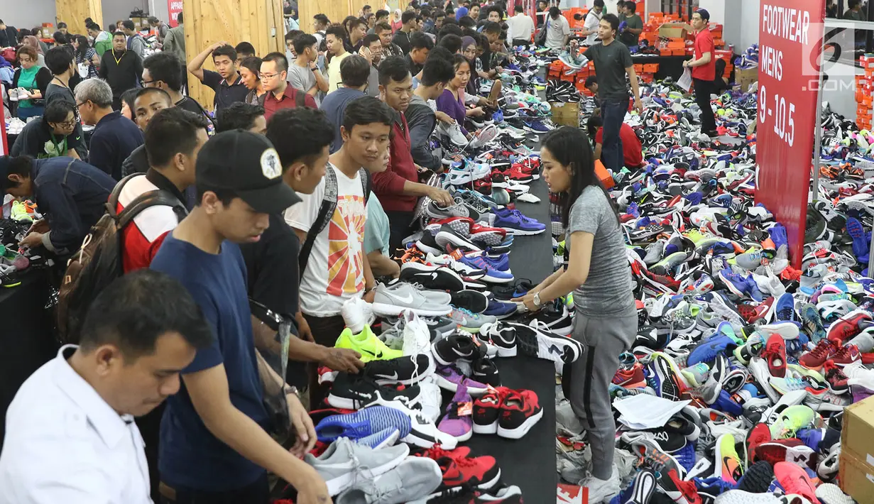 Pramuniaga melayani pengunjung yang membeli sepatu dalam Nike Bazaar di Mal Grand Indonesia, Jakarta, Rabu (23/8). Nike memberi diskon hingga mencapai 90 persen untuk semua produk sepatu lelaki dan perempuan. (Liputan6.com/Immanuel Antonius)