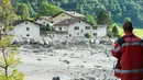 Seorang pria berada di lokasi tanah longsor yang menerjang desa Bondo di Swiss selatan (23/8). Polisi mengatakan akibat bencana tersebut delapan orang hilang. (Giancarlo Cattaneo / Keystone via AP)