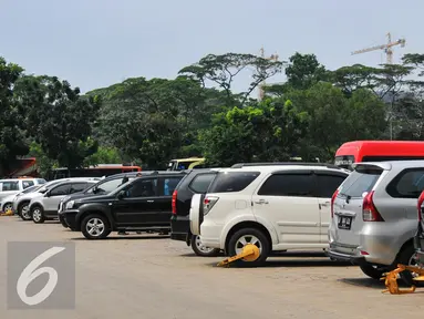 Sejumlah mobil hasil razia parkir liar dikumpulkan di lahan parkir IRTI Monas, Jakarta Pusat, Jumat (20/5). Pemilik kendaraan yang terkena razia baru dapat membawa mobil mereka setelah membayar denda. (Liputan6.com/Yoppy Renato)