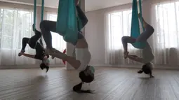 Para murid melakukan gerakan aerial yoga atau yoga udara di Aerial Jooga Studia, Kelapa Dua, Tangerang, Banten, Minggu (10/10/2021). Di masa pandemi, peminat olahraga yang berasal dari Amerika Serikat ini meningkat lebih dari 60 persen. (merdeka.com/Arie Basuki)