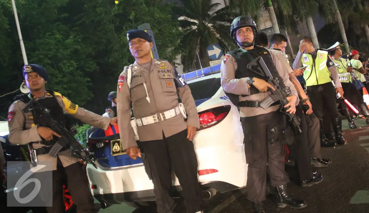 Petugas kepolisian bersenjata lengkap berjaga di kawasan Bundaran HI, Jakarta, Sabtu (31/12). Namun acara tersebut dibatalkan setelah Pemkot DKI berkoordinasi dengan Kepolisian Daerah Metro Jaya. (Liputan6.com/Immanuel Antonius)