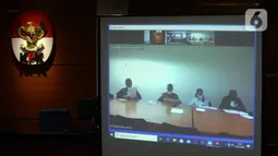 Mantan Komisioner KPU Wahyu Setiawan (kedua kiri) mendengarkan Jaksa Penutut Umum membacakan dakwaan saat sidang secara daring di Gedung KPK, Jakarta, Kamis (28/5/2020). Wahyu menjalani sidang dakwaan terkait kasus dugaan menerima suap pengurusan PAW anggota DPR dari PDIP. (merdeka.com/Dwi Narwoko)