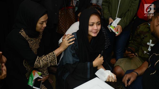 Istri gitaris grup band Seventeen Herman Sikumbang, Juliana Muhtar menangis saat menerima kedatangan jenazah suami di rumah duka di Pancoran, Jakarta, Senin (24/12). Uli begitu terpukul dengan meninggalnya sang suami. (Kapanlagi.com/Bayu Herdianto)