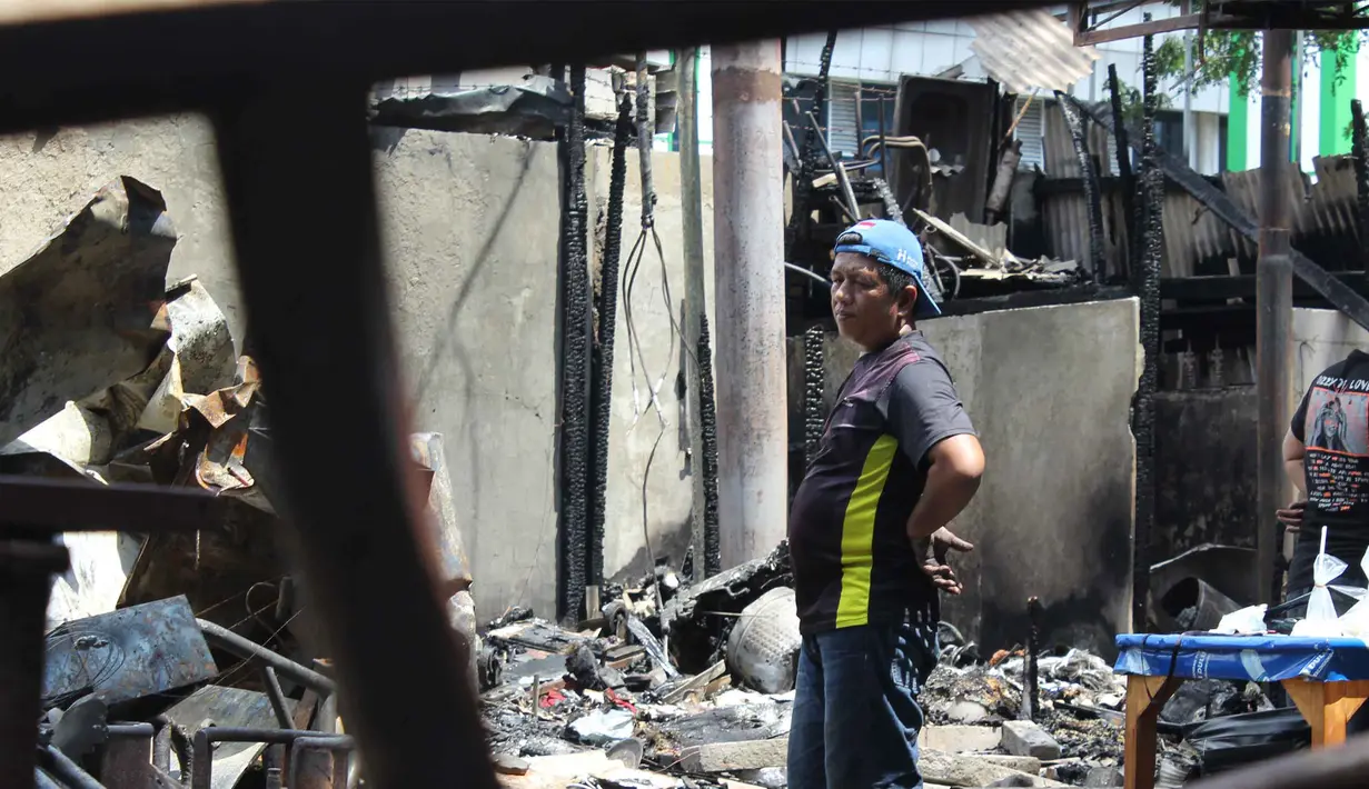 Dua orang penagih utang menjadi korban pengeroyokan brutal. Satu korban tewas seketika di lokasi kejadian, sementara satu lainnya menghembuskan napas terakhir di rumah sakit. Tampak dalam foto, pemilik kios membersihkan puing-puing bangunan usai kebakaran yang melanda deretan kios di kawasan Kalibata, Jakarta Selatan, pada Jumat (12/12/2025). (merdeka.com/magang/Rendi Saputra)